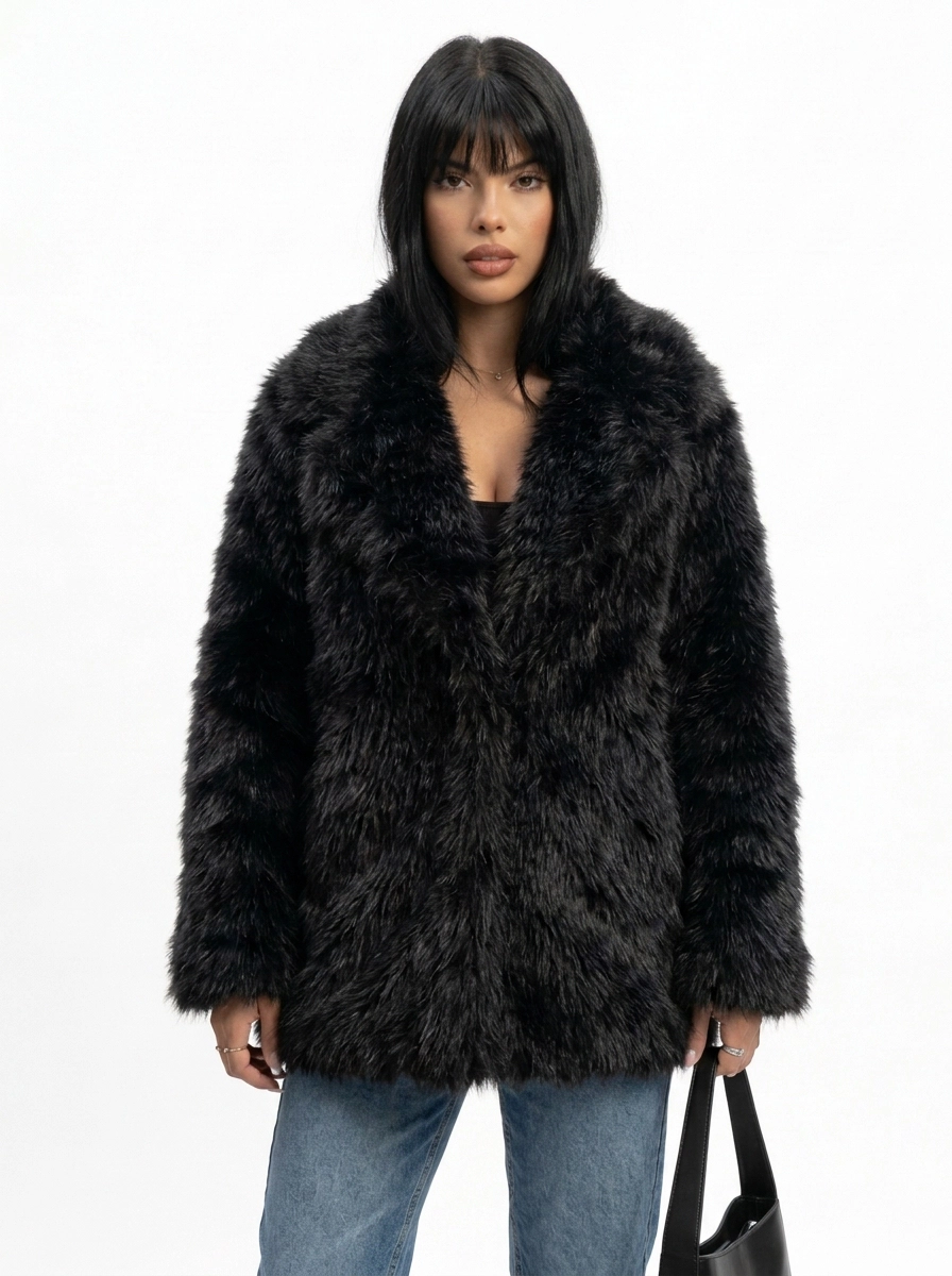Woman modeling a black faux fur coat with blue jeans