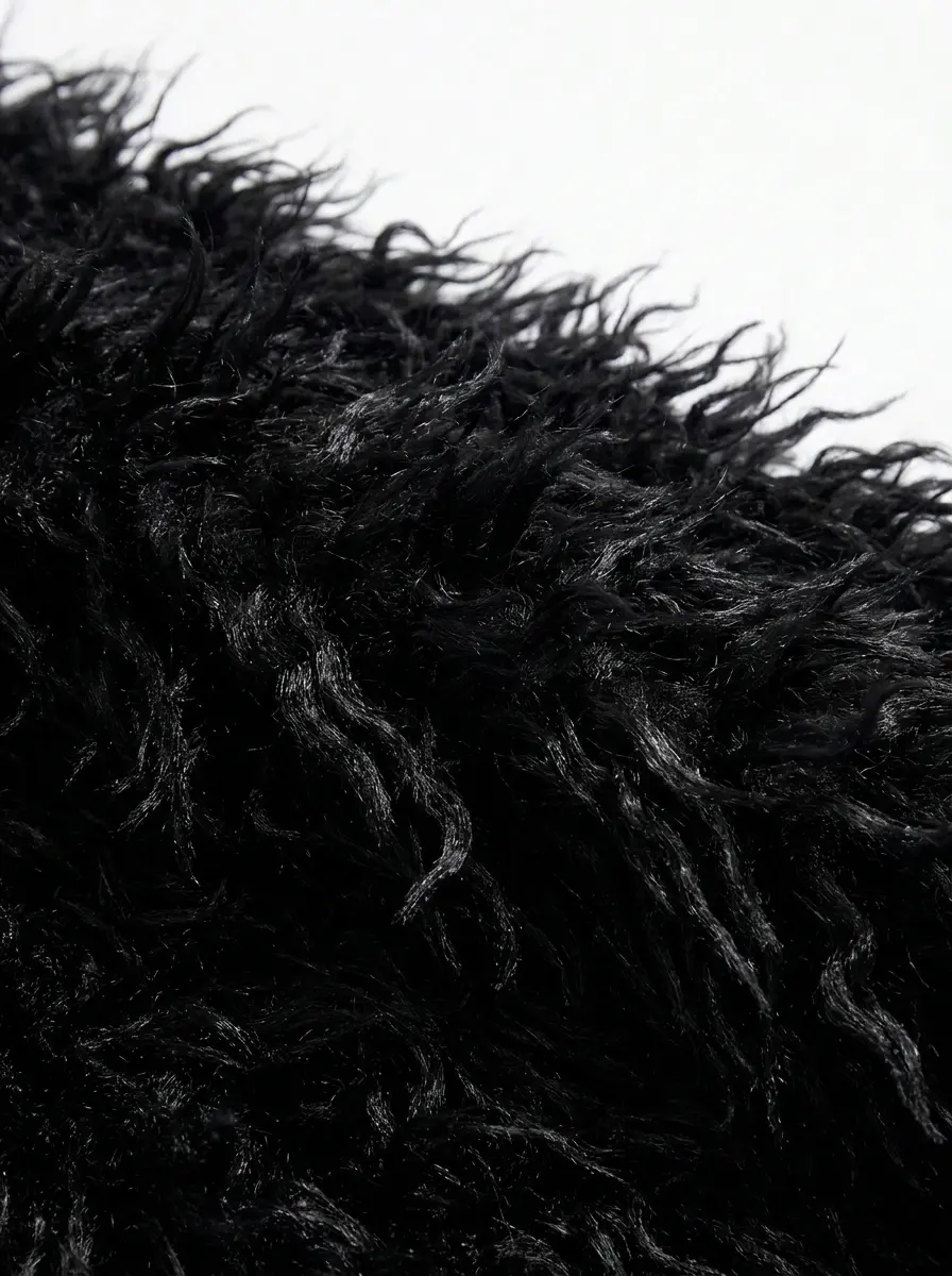 Black faux fur coat detail showing plush pile texture