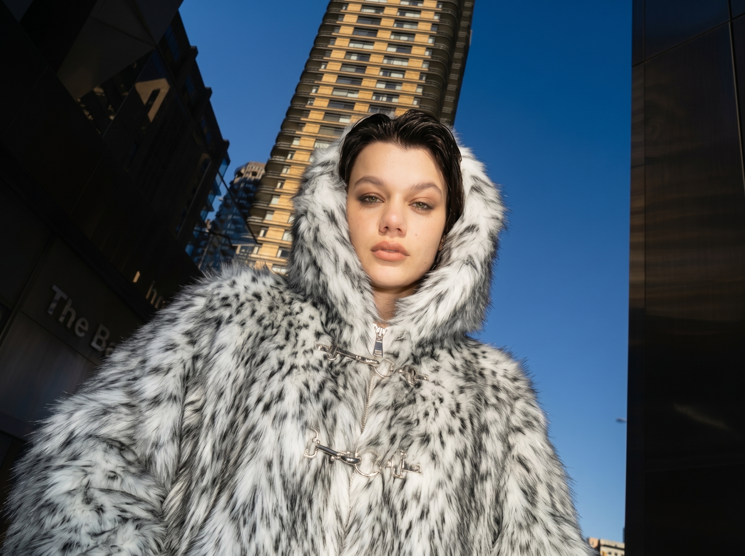 Woman wearing a soft faux fur coat in a neutral indoor setting