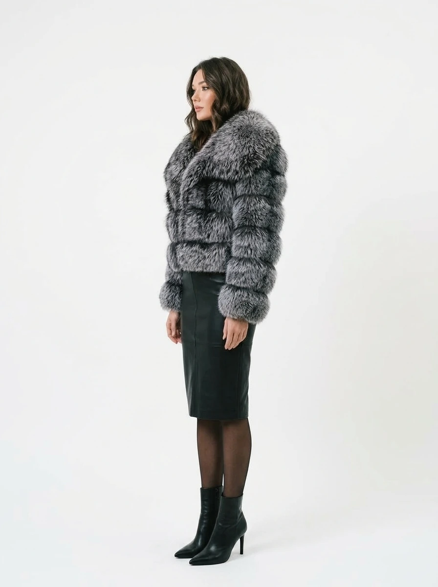 Side view of a woman wearing a charcoal gray short faux fur jacket with a black midi skirt
