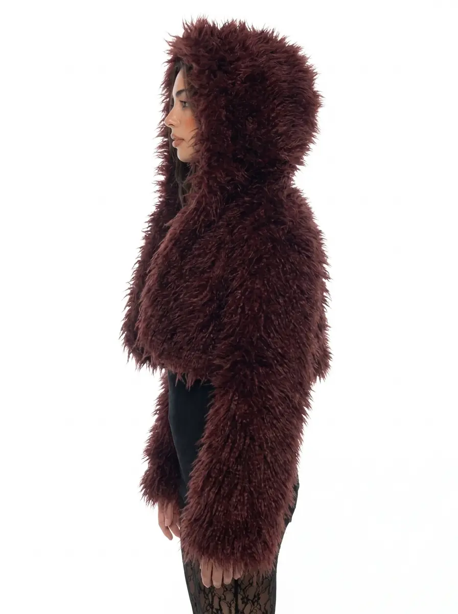 Side view of a woman wearing a maroon hooded faux fur jacket