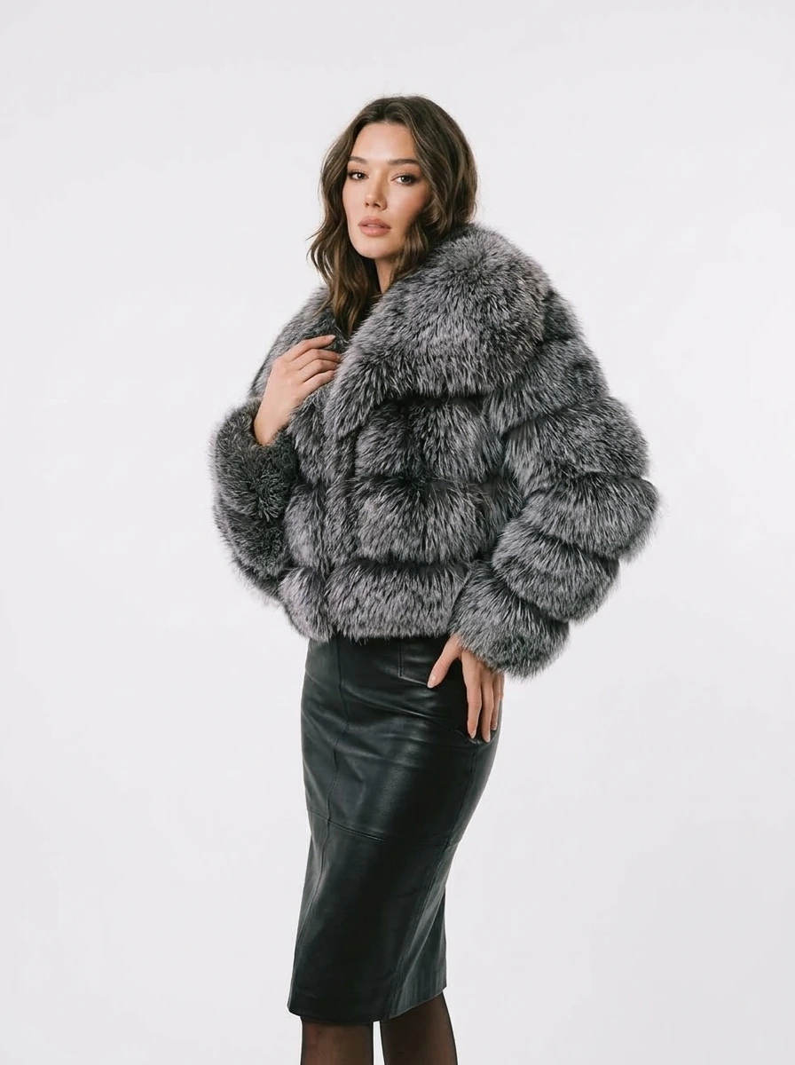 Three-quarter view of a charcoal gray cropped faux fur jacket with an oversized lapel collar