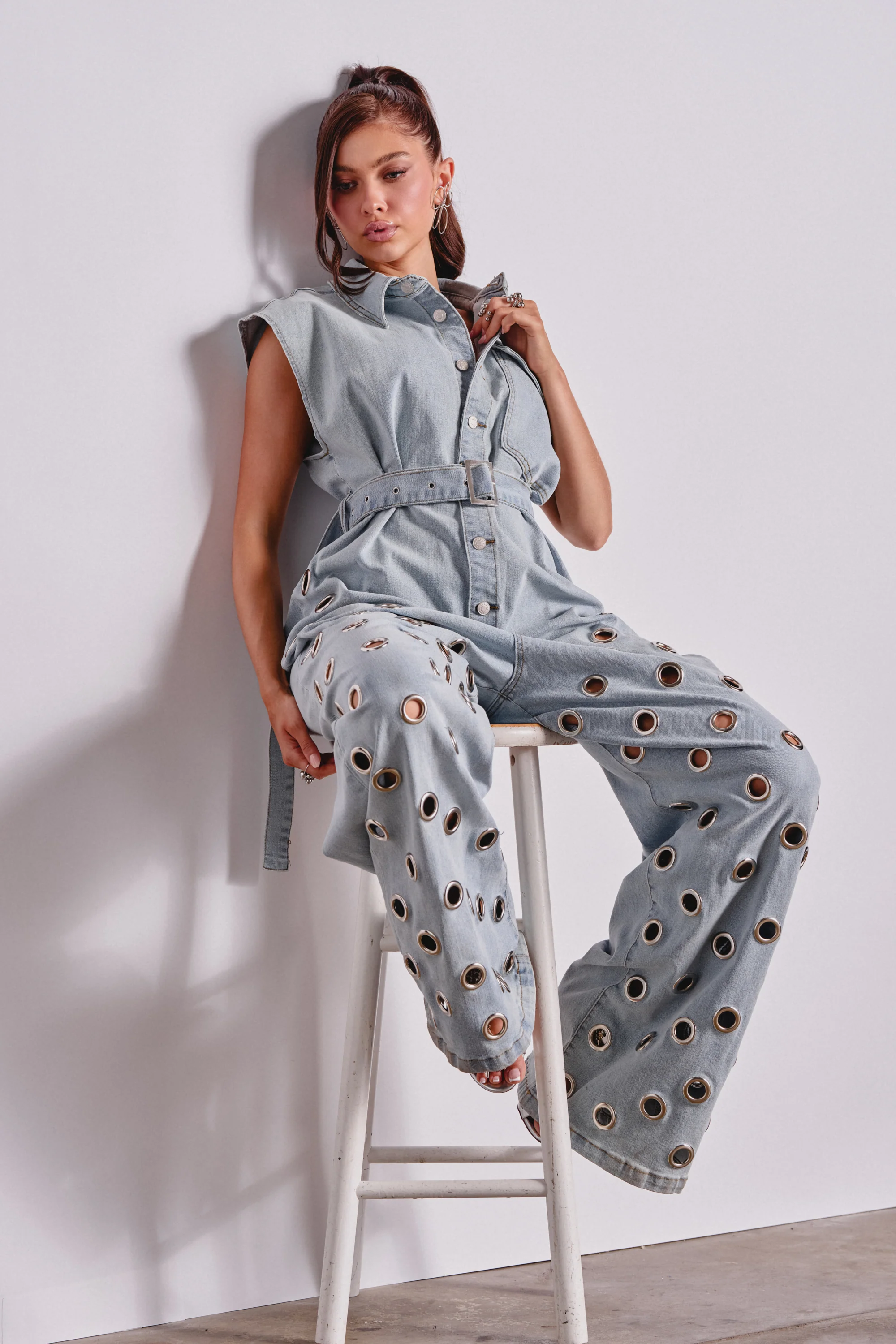 PLAY YOUR CARDS RIGHT DENIM JUMPSUIT WITH GROMMETS IN LIGHT WASH - Akira Store