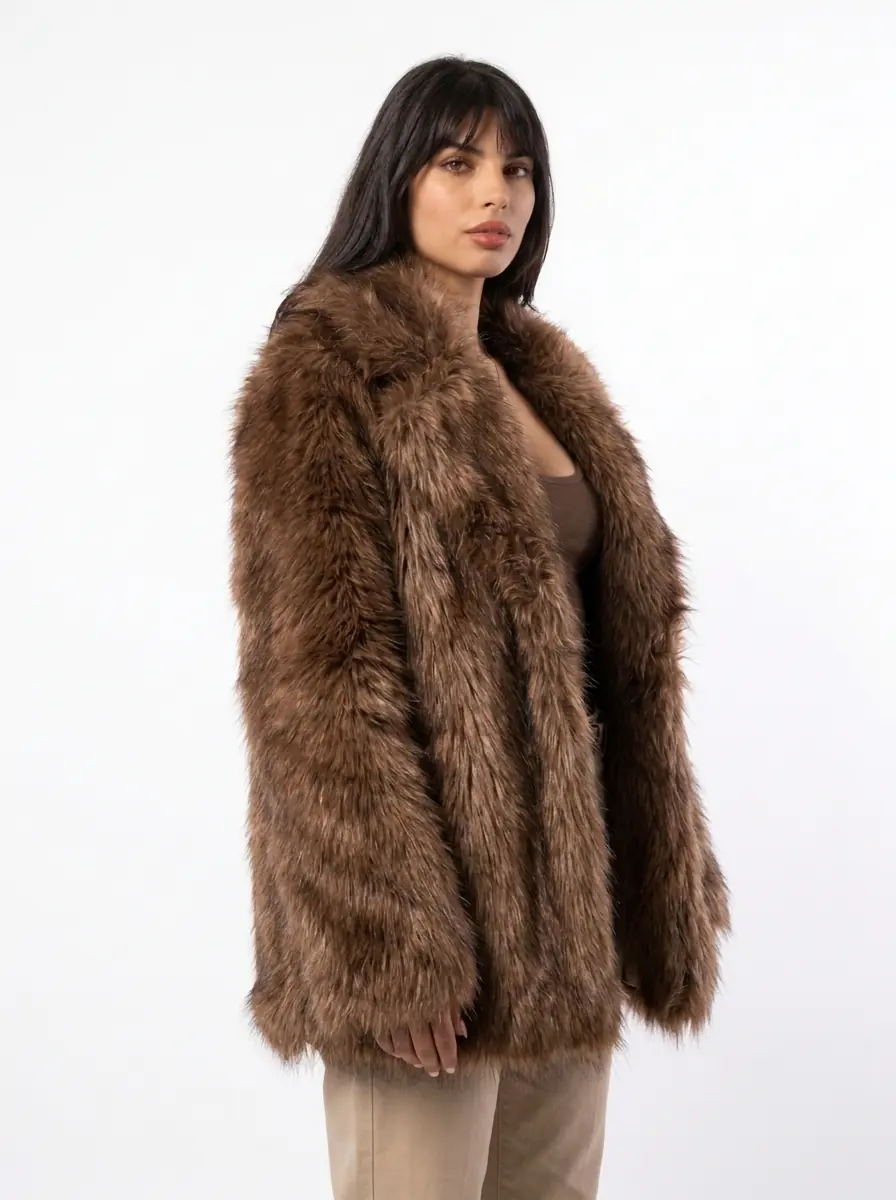 Woman modeling a light brown faux fur coat on a white background