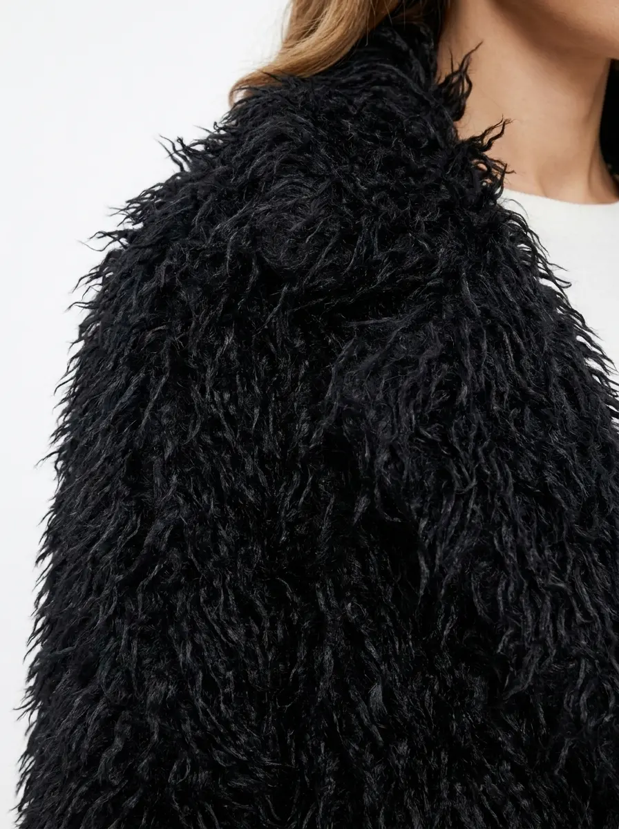 Close-up of soft black faux fur texture on long coat