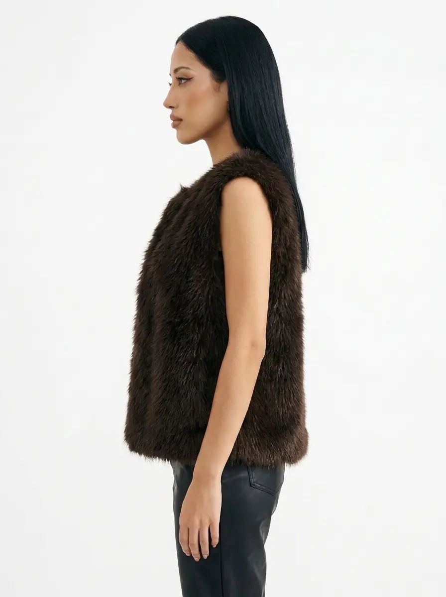 Side view of a woman wearing a dark brown faux fur vest
