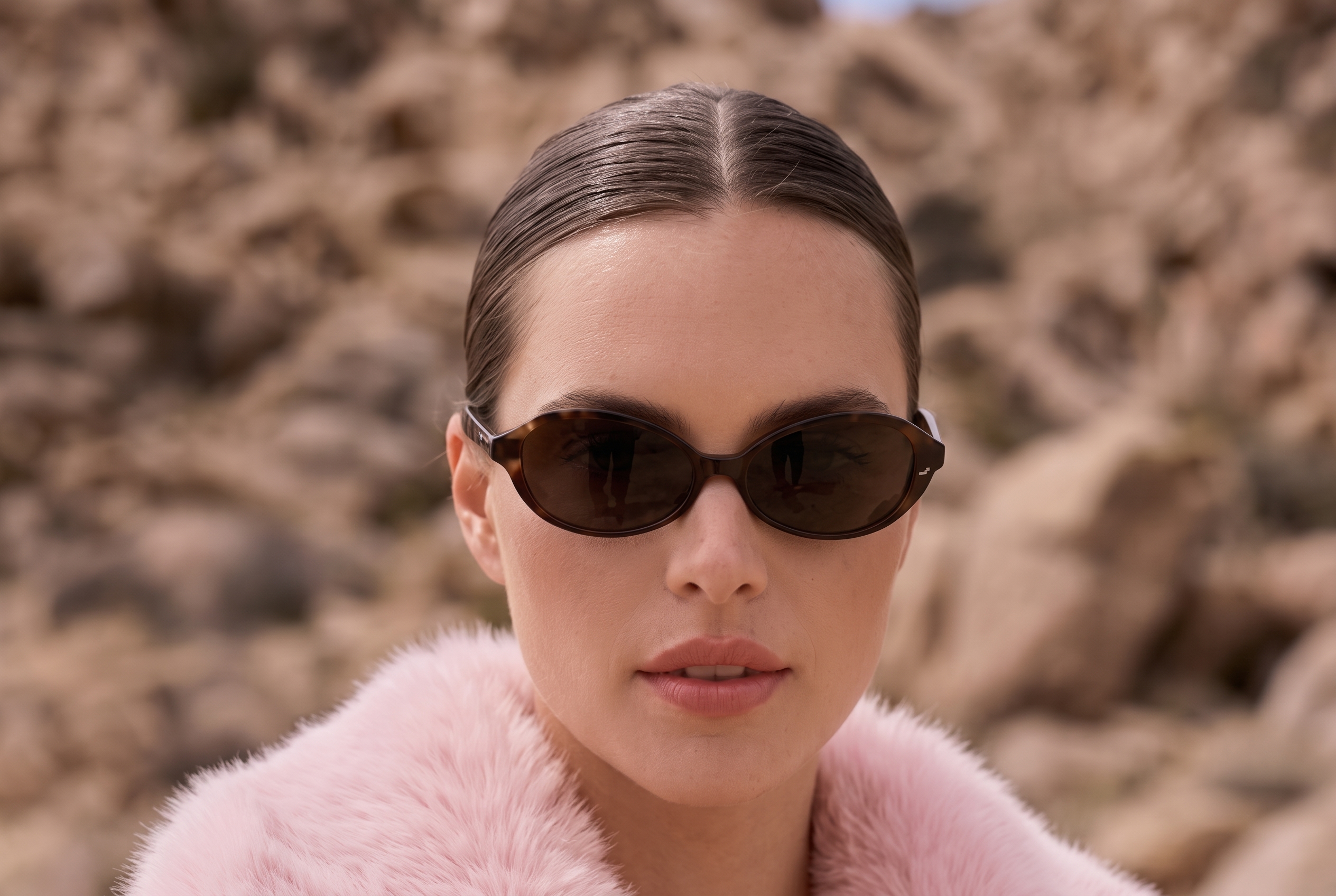 Woman wearing a pink faux fur coat and sunglasses outdoors