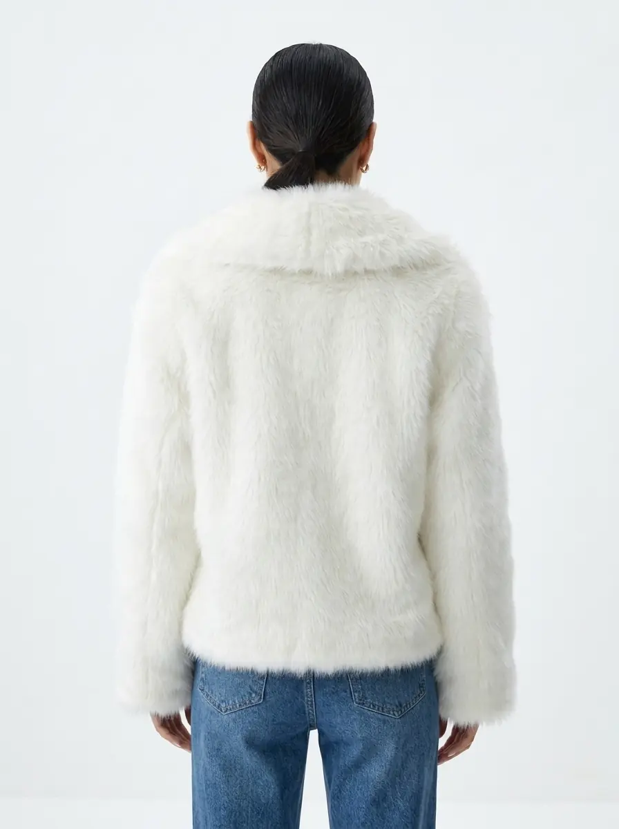 Back view of a women's white faux fur jacket
