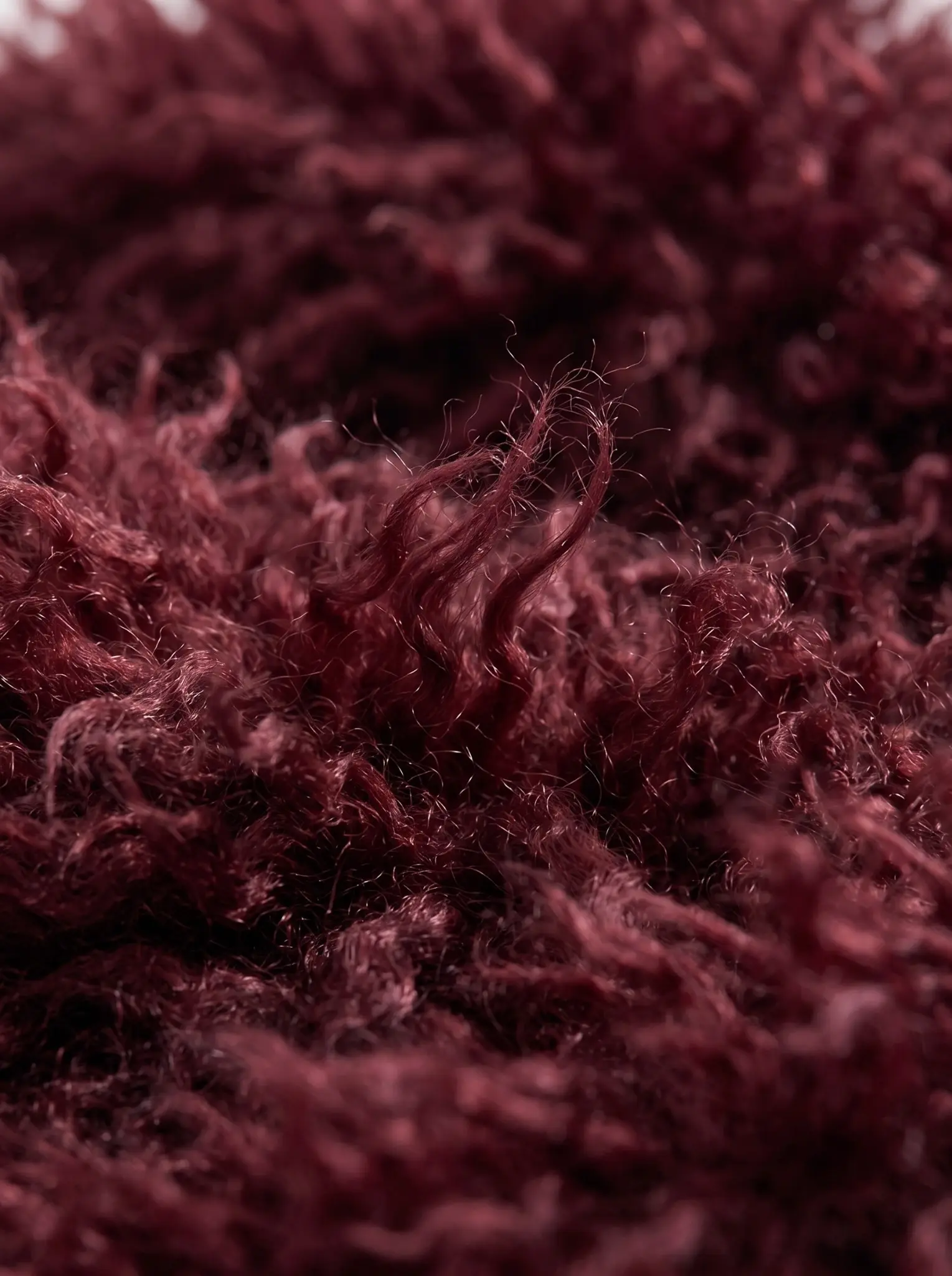 Close-up of the soft maroon shaggy faux fur texture