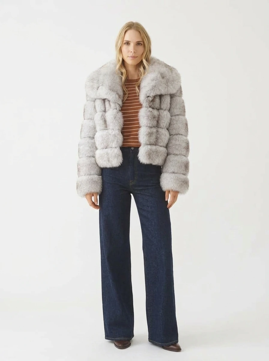 Woman wearing a gray short faux fur jacket with an oversized lapel collar and wide-leg jeans, front view