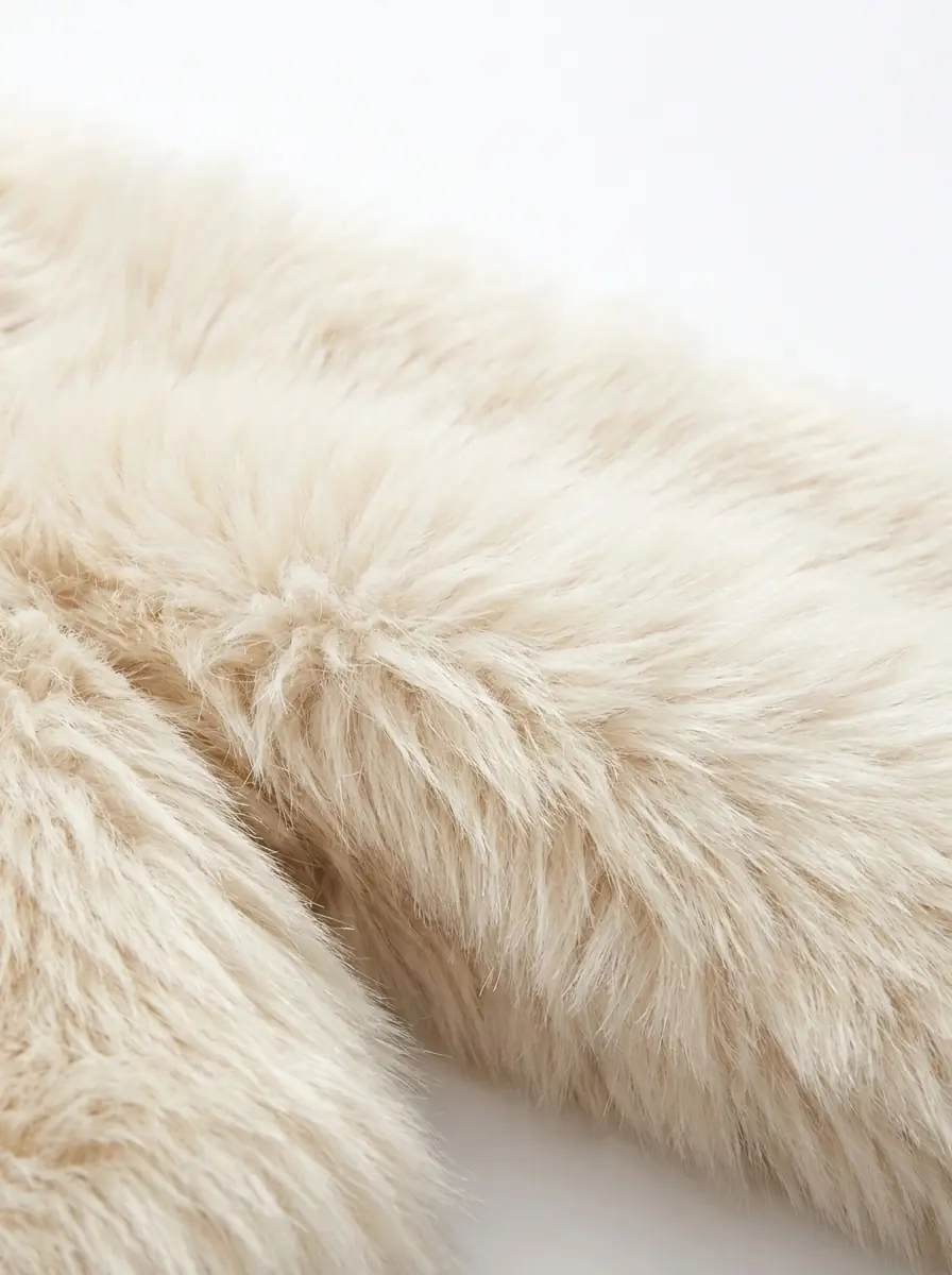 Close-up of soft cream faux fur jacket texture