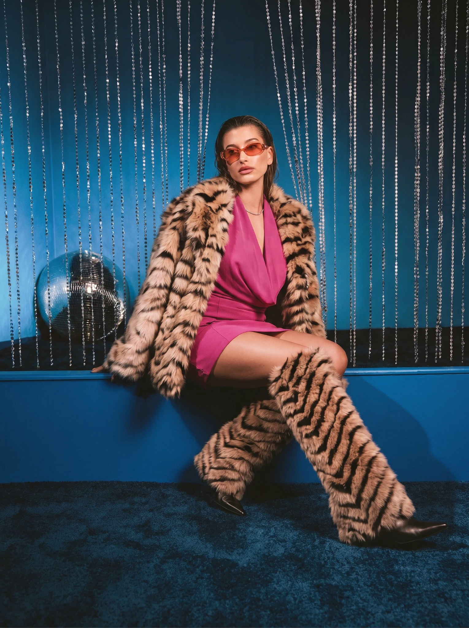 Fashion portrait of a woman wearing a tiger-print faux fur coat and pink dress