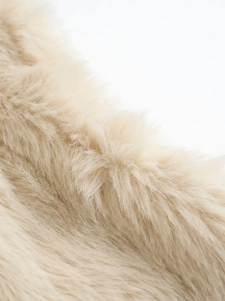 Close-up of soft cream faux fur vest texture