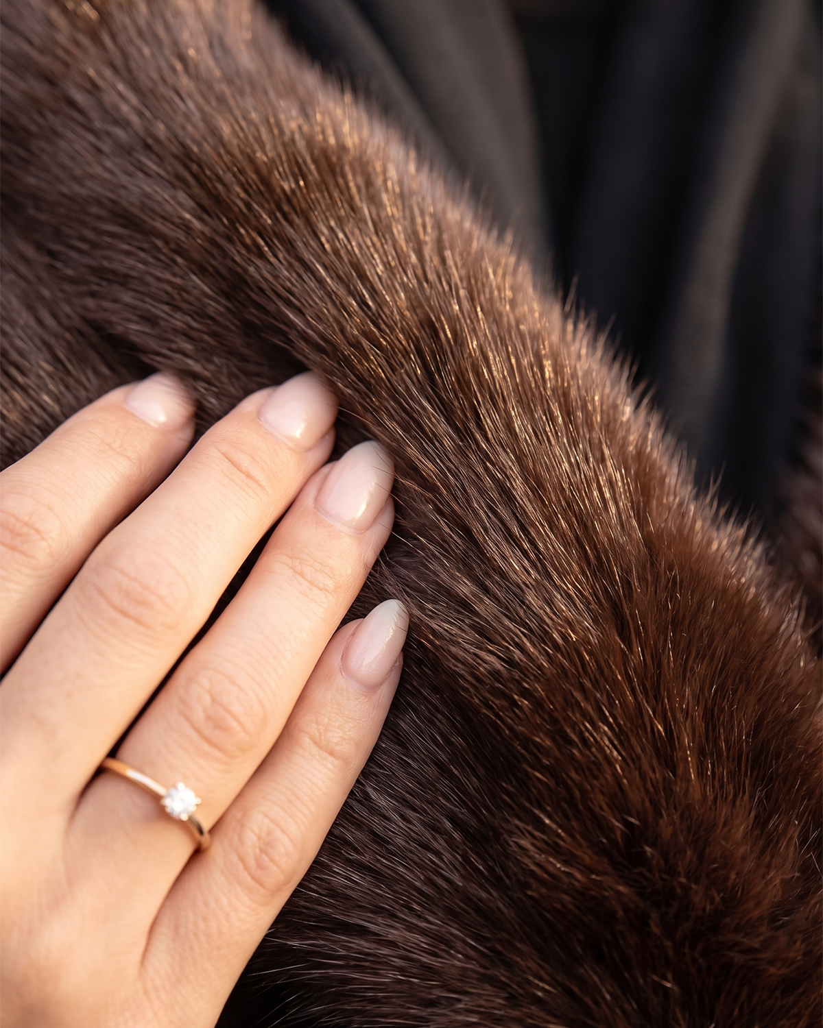 Hand touching plush dark brown faux fur fabric