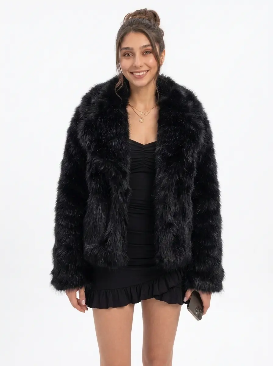 Woman modeling a black faux fur jacket with a black mini dress