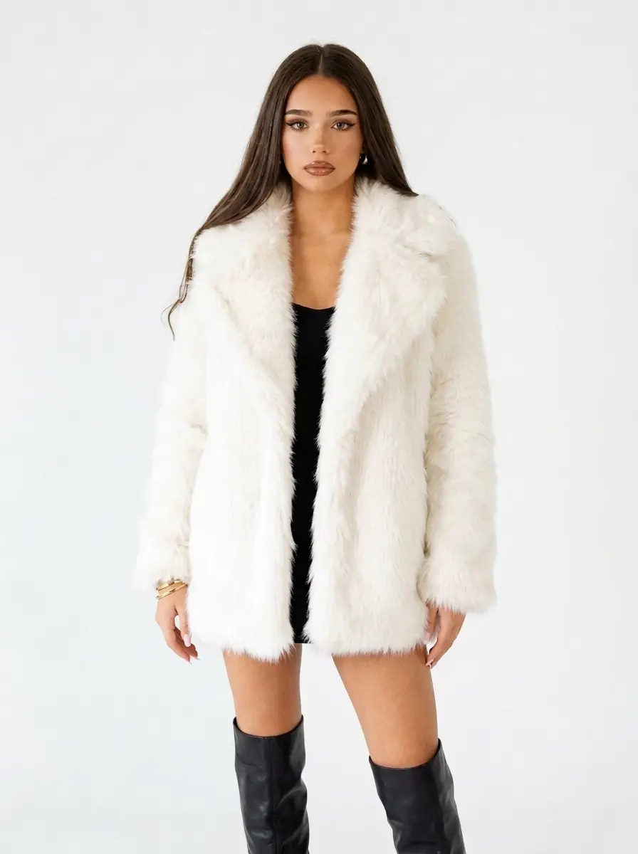 Woman modeling a white faux fur coat on a white background
