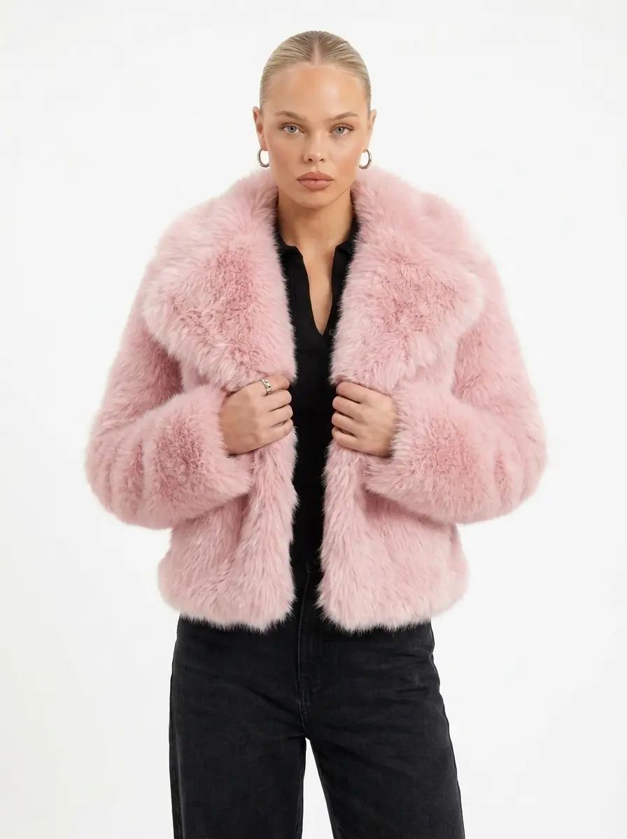 Woman modeling a pink faux fur jacket with black pants