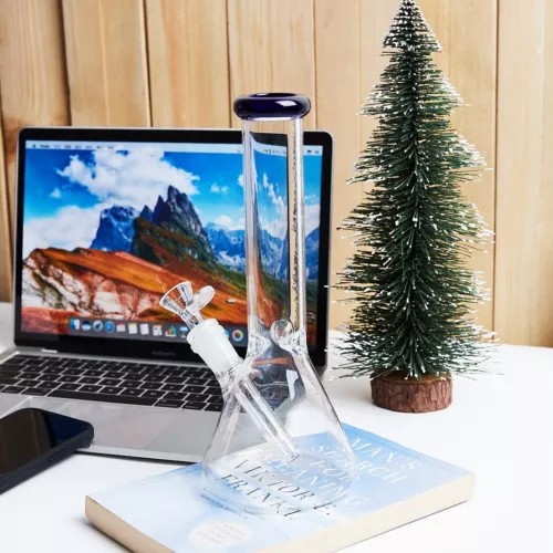 Blue 10-inch beaker bong standing on a desk next to a laptop