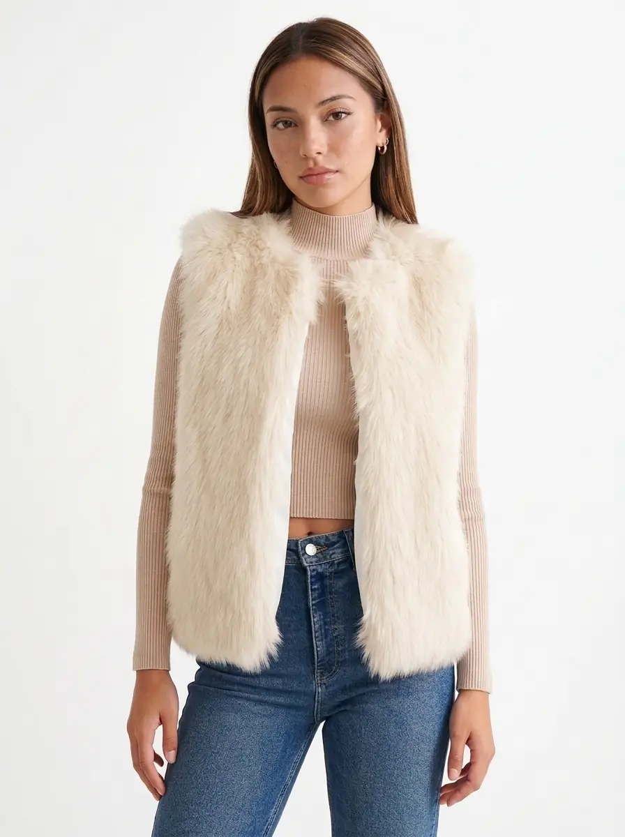 Front view of a woman modeling a cream faux fur vest