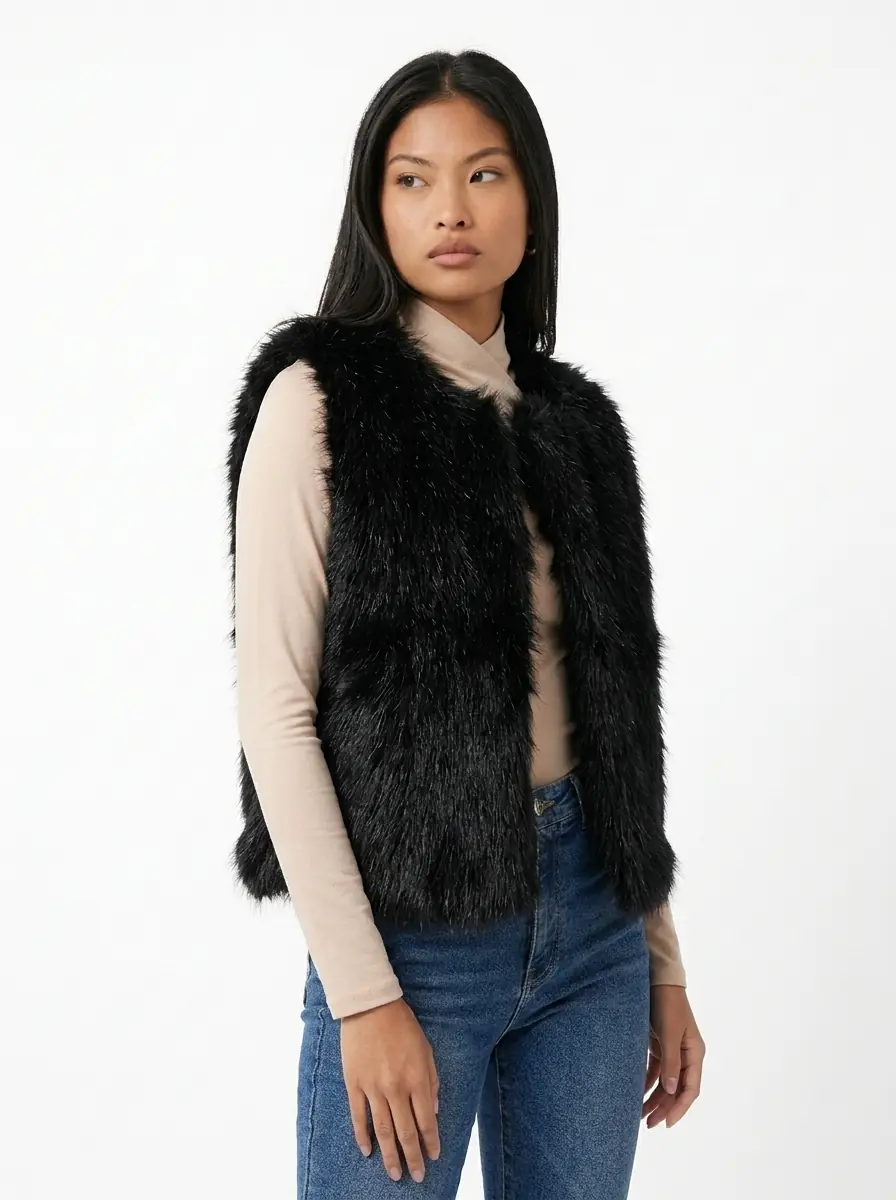 Woman wearing a black faux fur vest in a three-quarter view