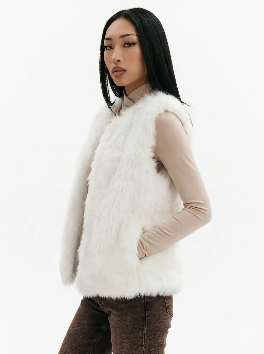 Woman modeling a white faux fur vest in a three-quarter view