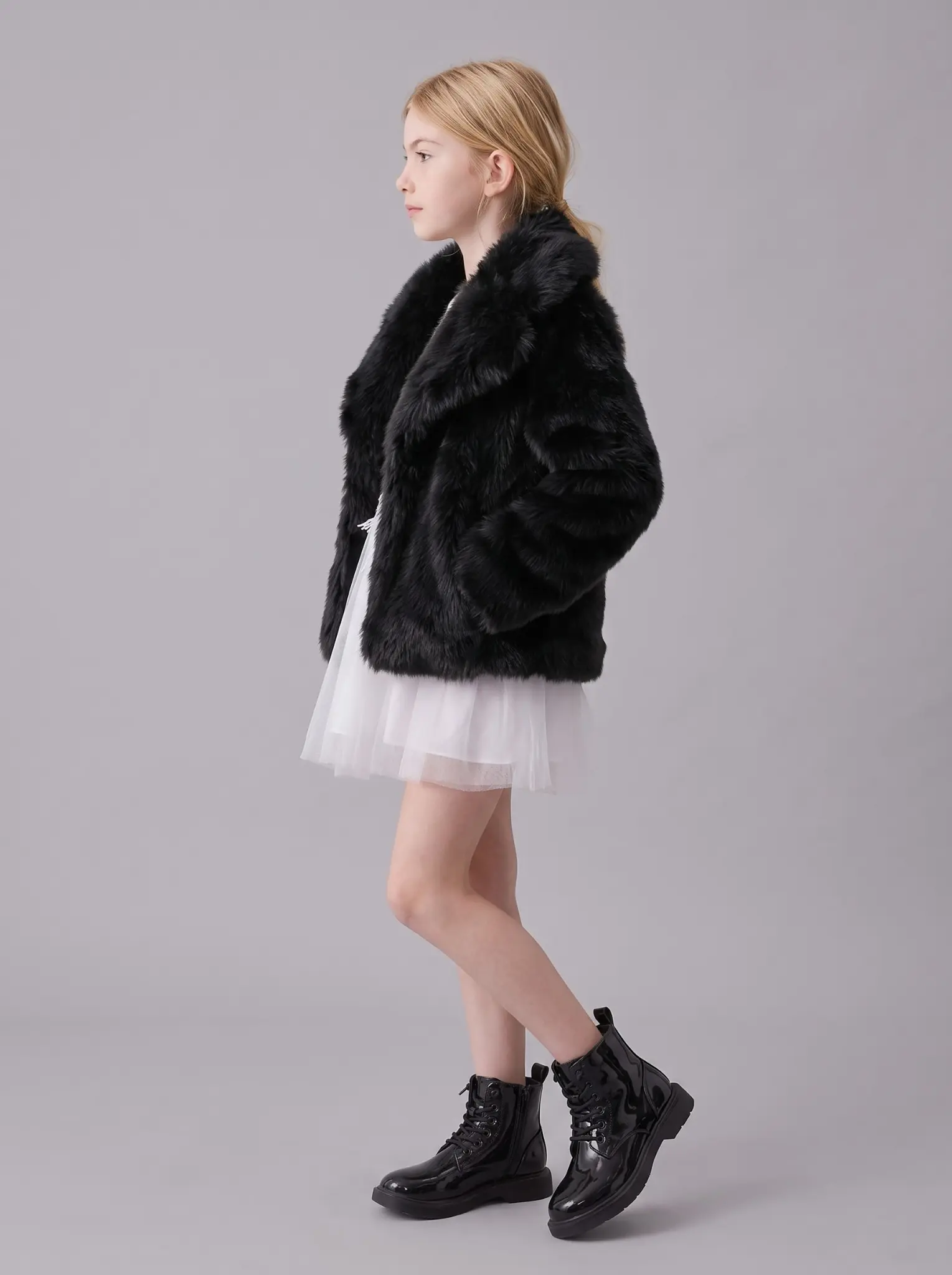 Side profile of a girl wearing a black faux fur jacket