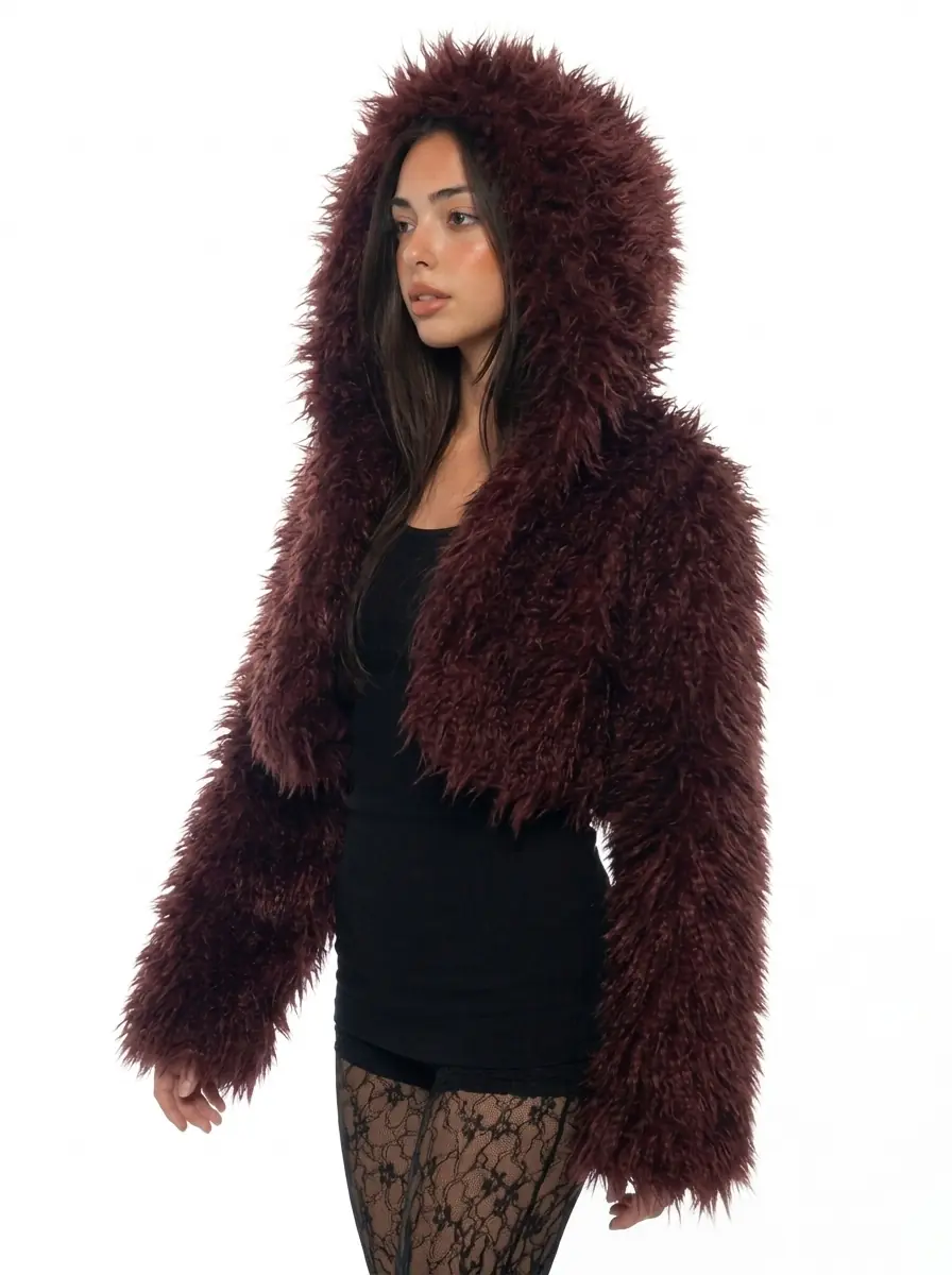 Woman wearing a maroon hooded faux fur jacket in a three-quarter view