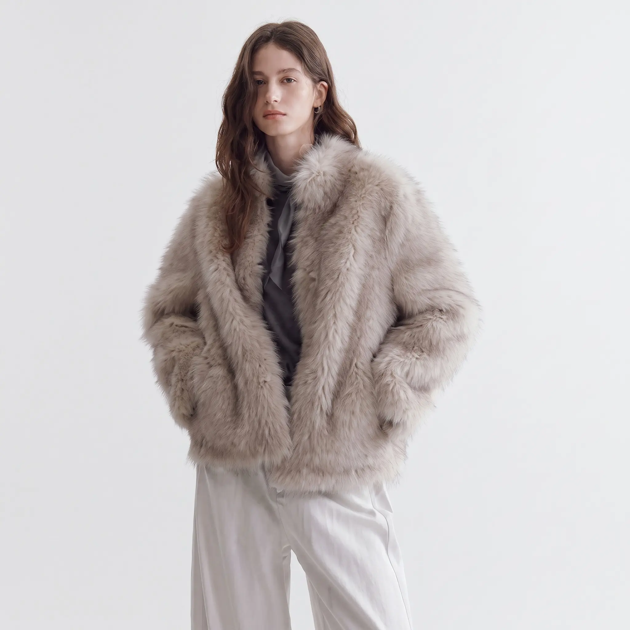 Woman modeling a beige faux fur jacket against a minimalist studio background