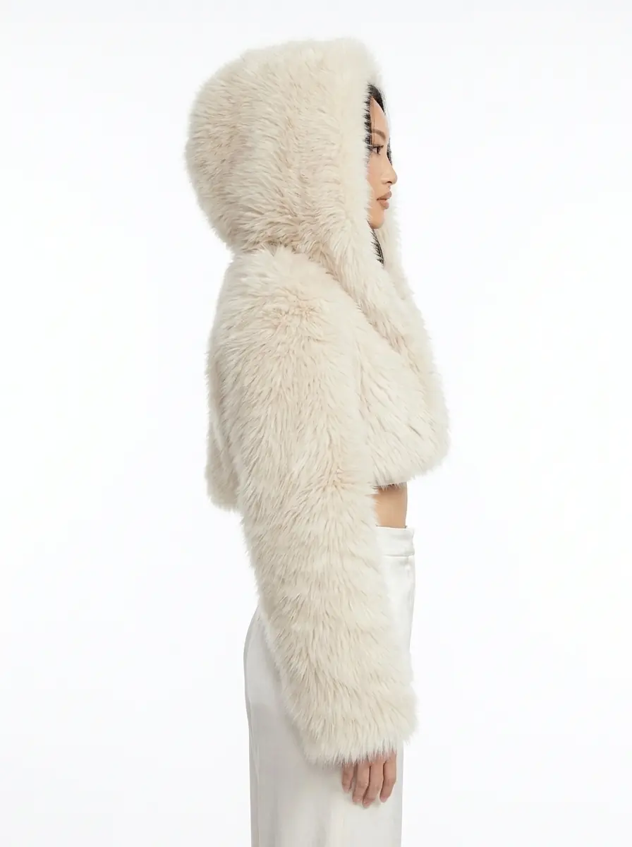 Side view of a woman wearing a cream hooded cropped faux fur jacket